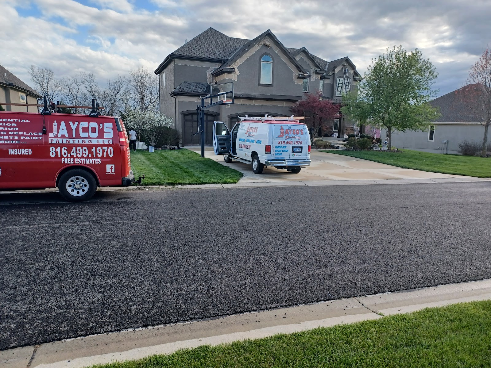Jayco's Painting work vans parked at a residential job site